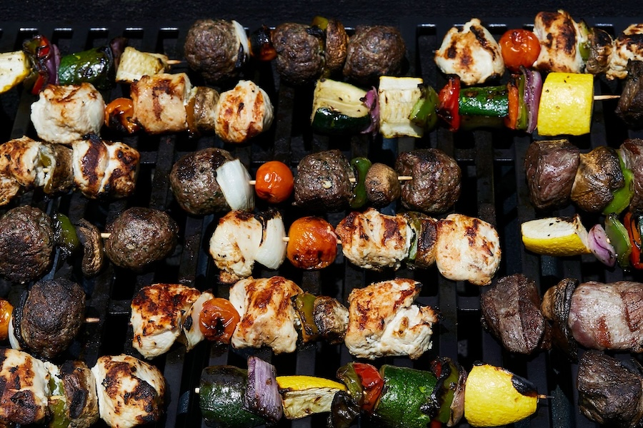 rows of kabobs with chicken, beef, lamb and colorful vegetables