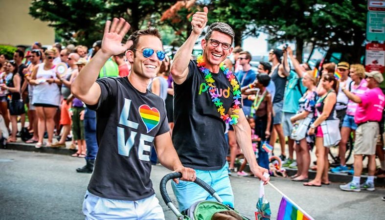 Paar zu Fuß mit Kind während der Capital Pride Parade - LGBTQ-Sommerveranstaltungen in Washington, DC