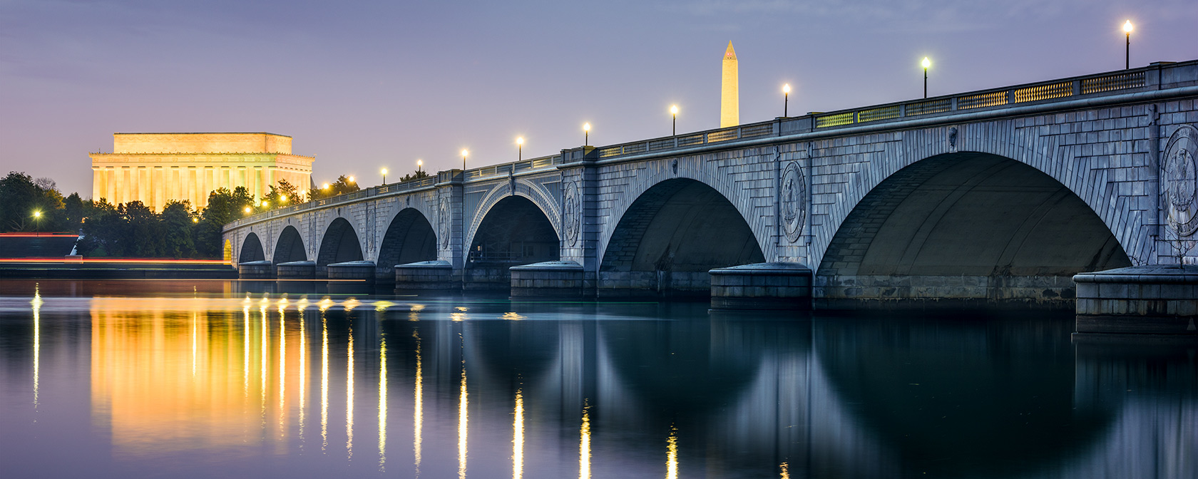 Arlington Bridge iluminado por la noche con el horizonte de DC con el Monumento a Lincoln y el Monumento a Washington