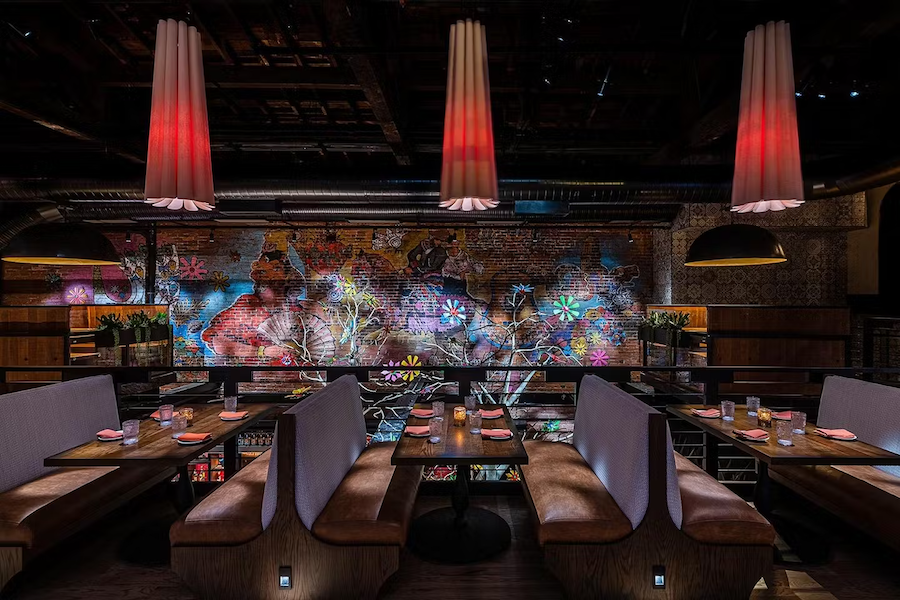 Stylish dining room at Sagrada restaurant featuring checkered floors, elegant lighting, and an open bar with warm, ambient tones.