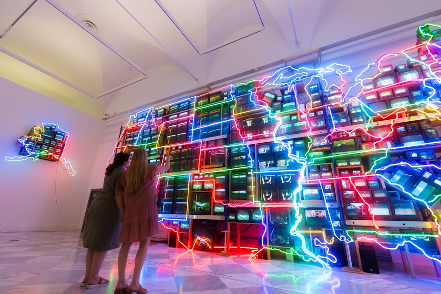 Two people view Nam June Paik’s neon and video installation Electronic Superhighway at the Smithsonian American Art Museum.
