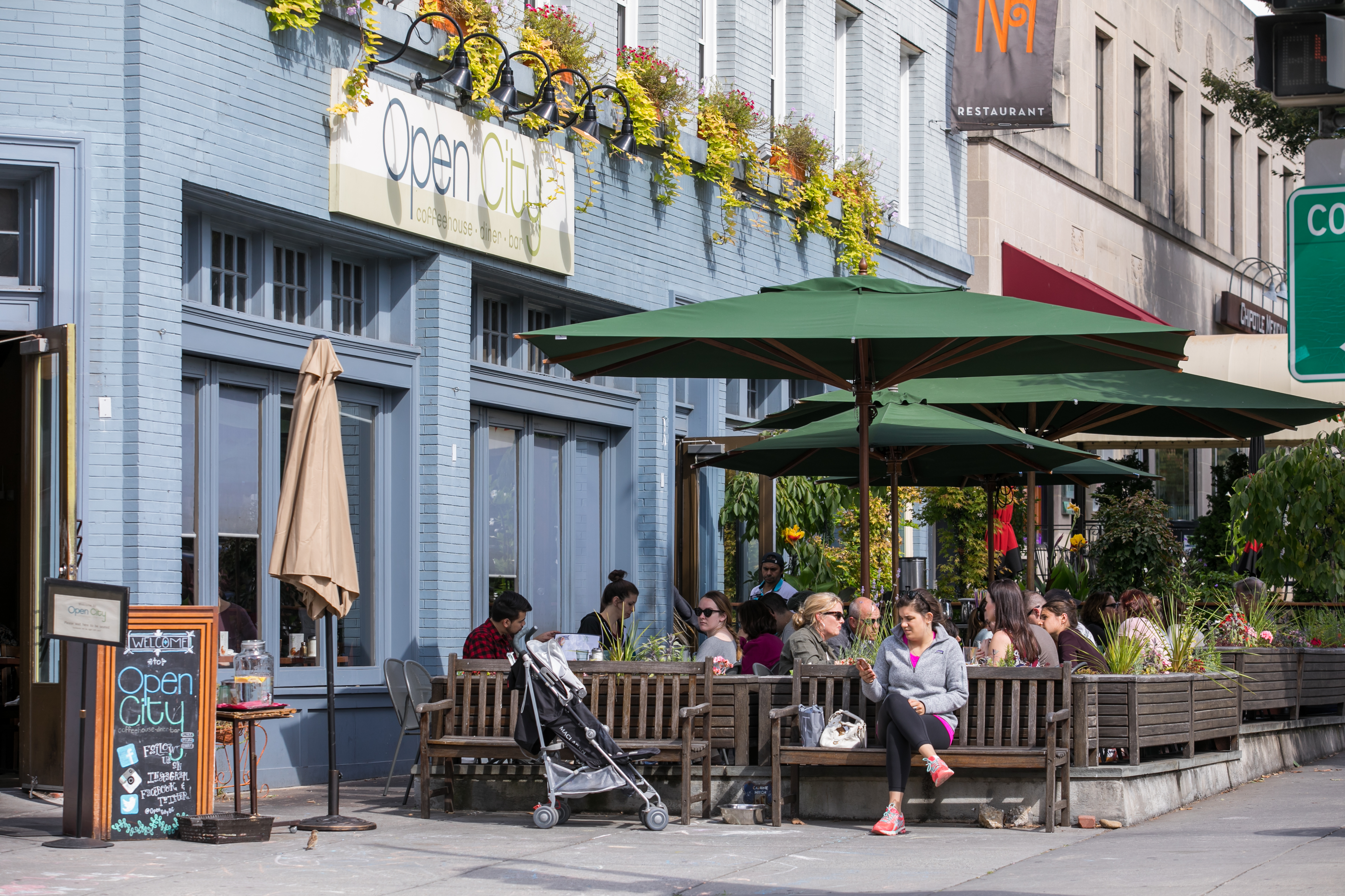 People enjoy outdoor seating at Open City in Washington, DC on a sunny day.