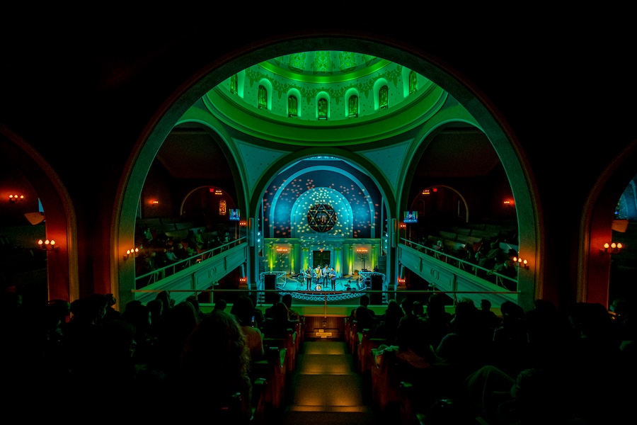 An audience watches a live performance beneath the domed ceiling inside Sixth & I Historic Synagogue.