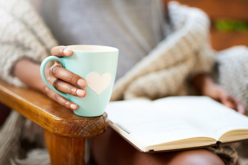 Woman holding mug and reading a book