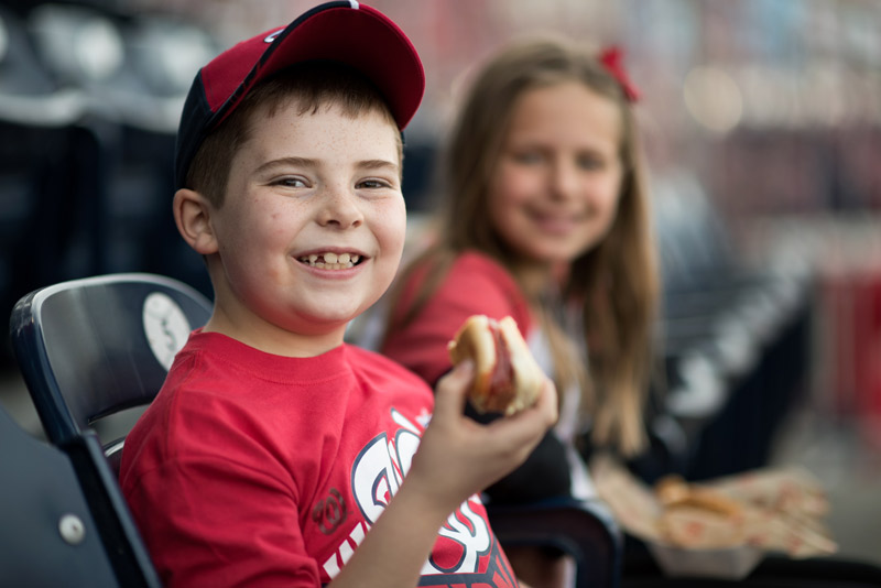 Young Nationals fan with hot dog - Where to eat and drink at Nationals Park in Washington, DC
