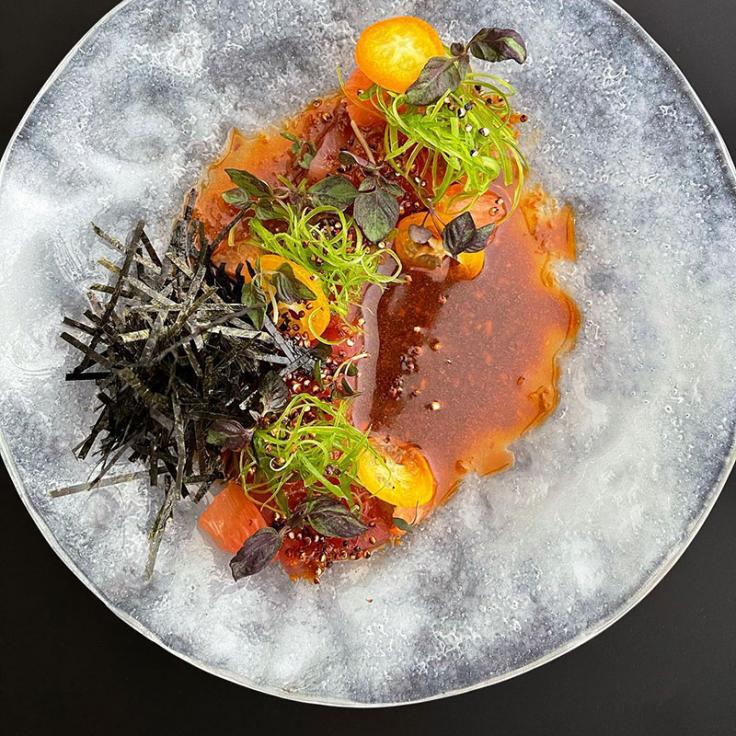 Plate of food with akami tuna with soy rayu, kumquats, and popped quinoa from Cranes, a restaurant specializing in Spanish Kaiseki cuisine.