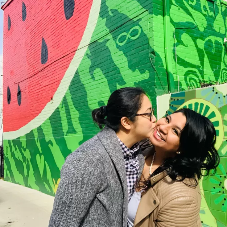 Couple in front of watermelon mural house