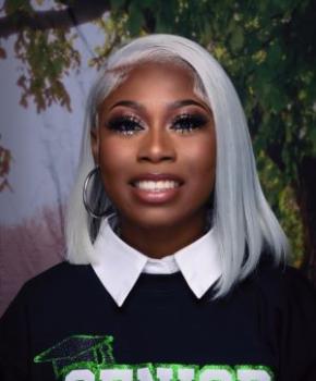 akira wilson, a young black woman with platinum blonde hair and flawless makeup, smiles for her professional headshot