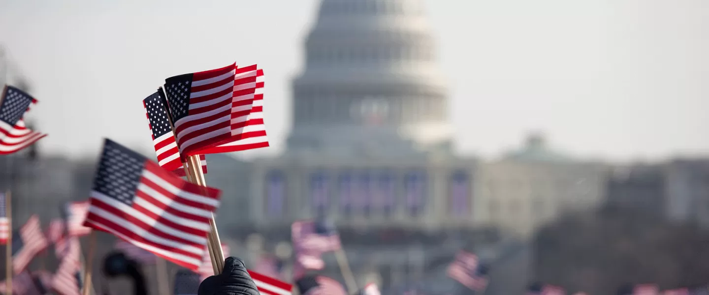 US Capitol with waving American flags