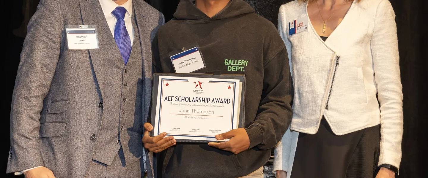 John Thompson holds his AEF scholarship in between Michael Akin and Claire Carlin