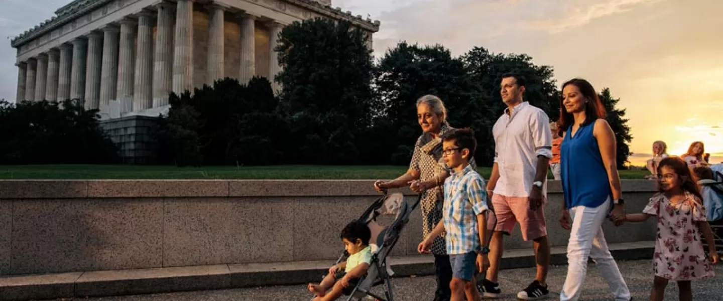 Family walking on the National Mall in front of the Lincoln Memorial during a summer evening in Washington, DC