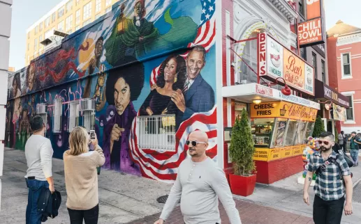 Guests Taking Photo of Ben's Chili Bowl Mural
