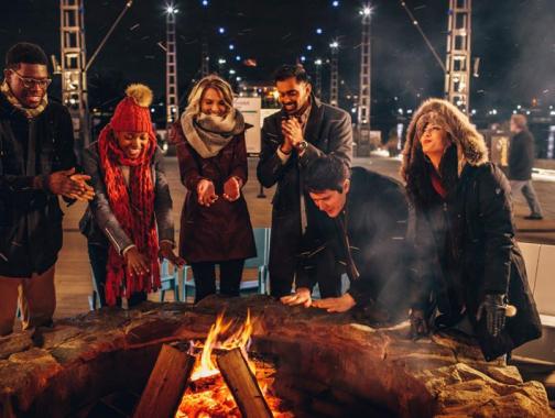 Friends gathered around the fire at The Wharf - Ways to make the most of Winter in Washington, DC