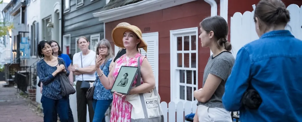 A tour guide speaks to a group during a historic walking tour in Georgetown, Washington, DC.