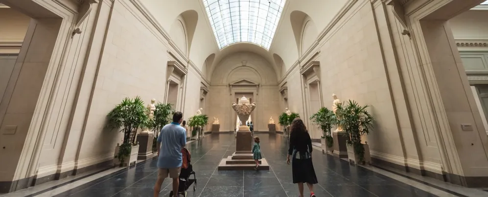People walk down a grand hallway at the National Gallery of Art.