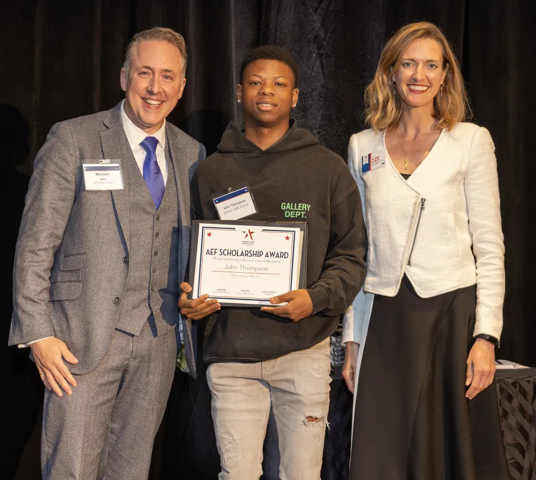 John Thompson holds his AEF scholarship in between Michael Akin and Claire Carlin